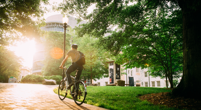 cyclist on campus pedaling up a hill